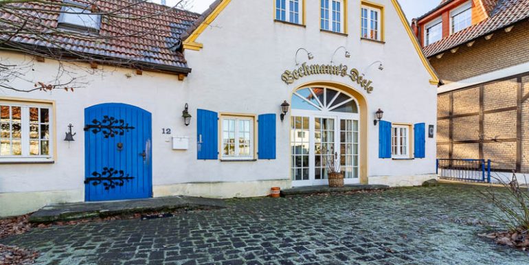 Charmanter historischer Hof mit malerischem Eingangsbereich und charakteristischen blauen Fensterläden – einladend und idyllisch gelegen.